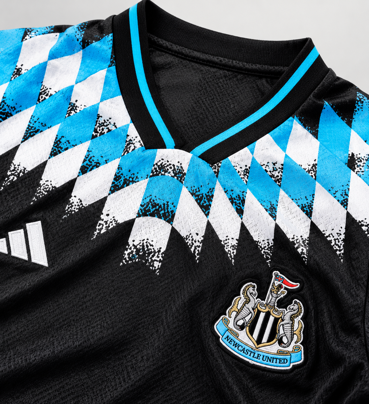 Newcastle United 26/27 Reissue Black – détail du col, du blason et du motif