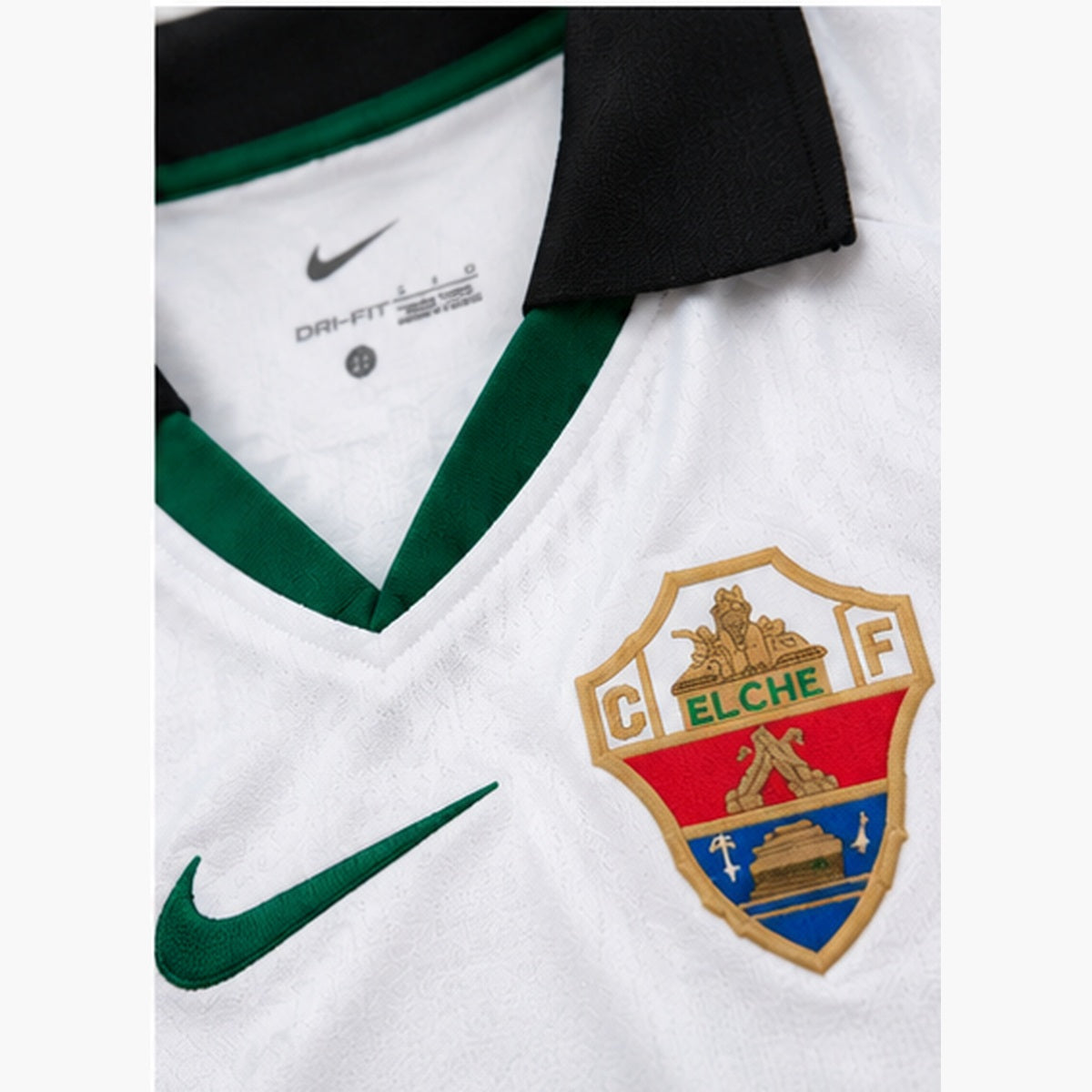 Gros plan du col, de l'écusson et du tissu du maillot domicile Elche CF 2026-2027