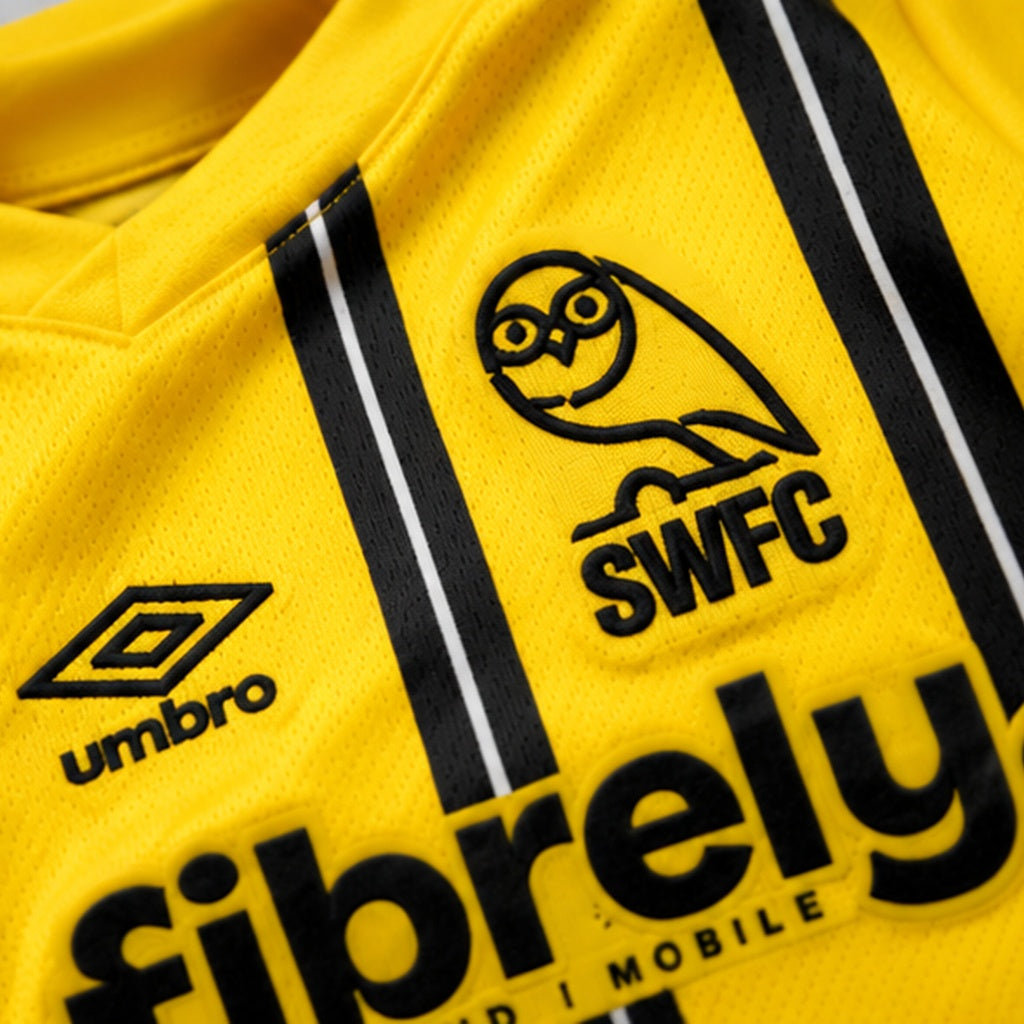 Gros plan du tissu jaune, des bandes noires, du logo Umbro et de l'écusson Sheffield Wednesday