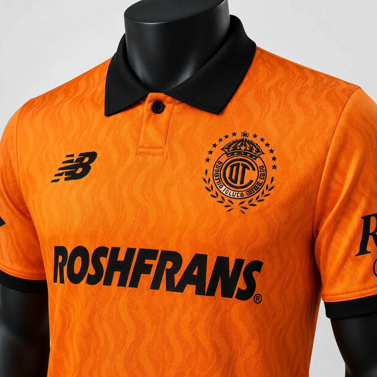 Détail du col noir, de l’écusson Toluca et du tissu orange